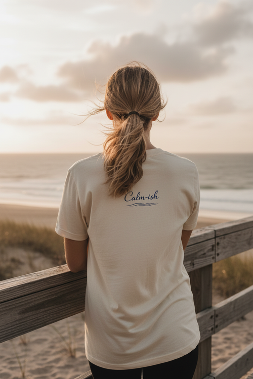 Calm-ish Tee back graphic - leaning on beach railing overlooking ocean